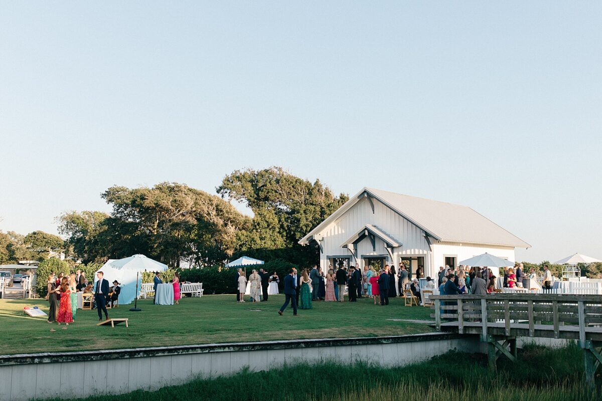 Wedding guests during cocktail hour near the water at the Beaufort Hotel 