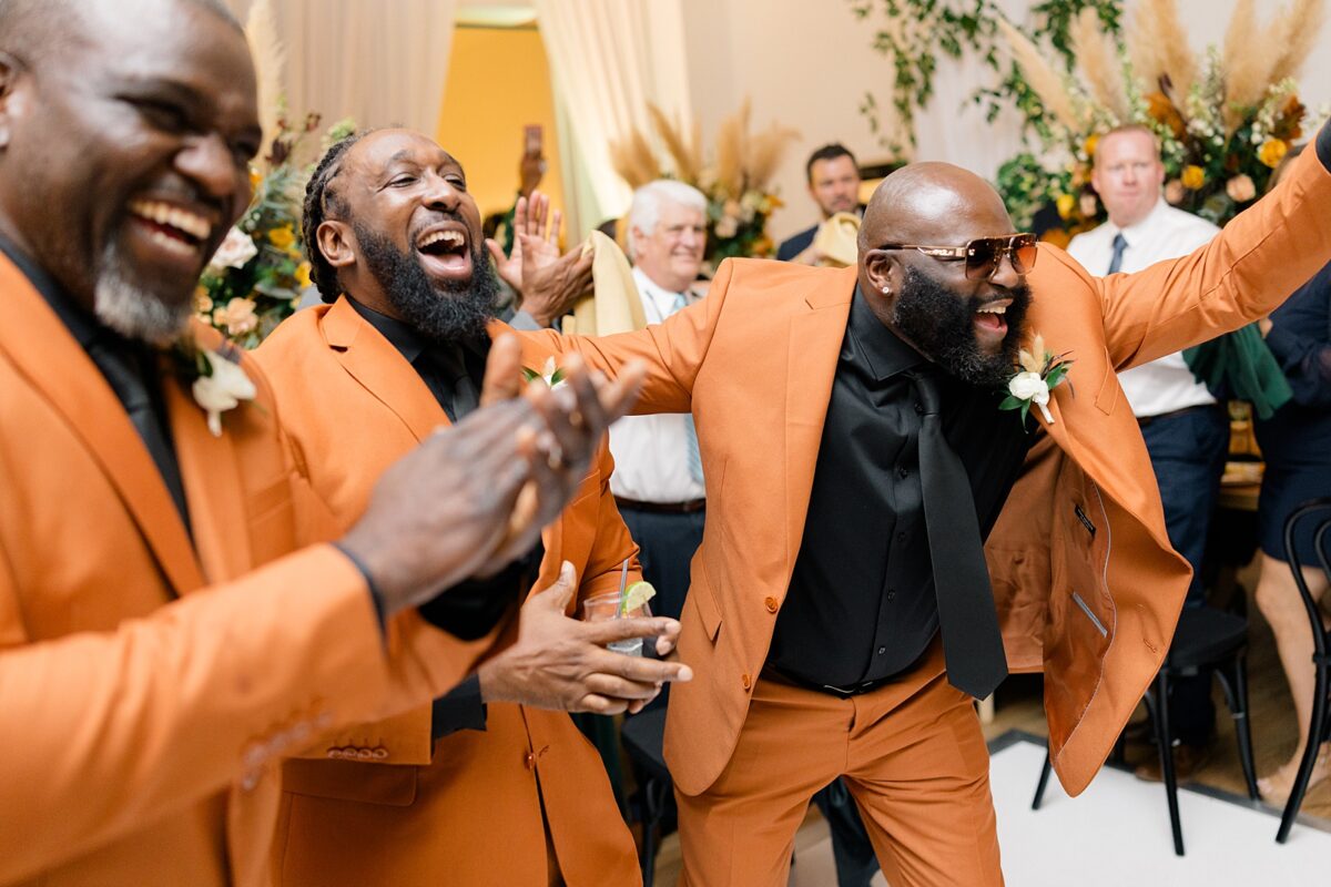 Deep and bold orange suits and fall wedding at Kindred Wedding and Event venue. A wedding designed by Brittanie Raquel Events. 