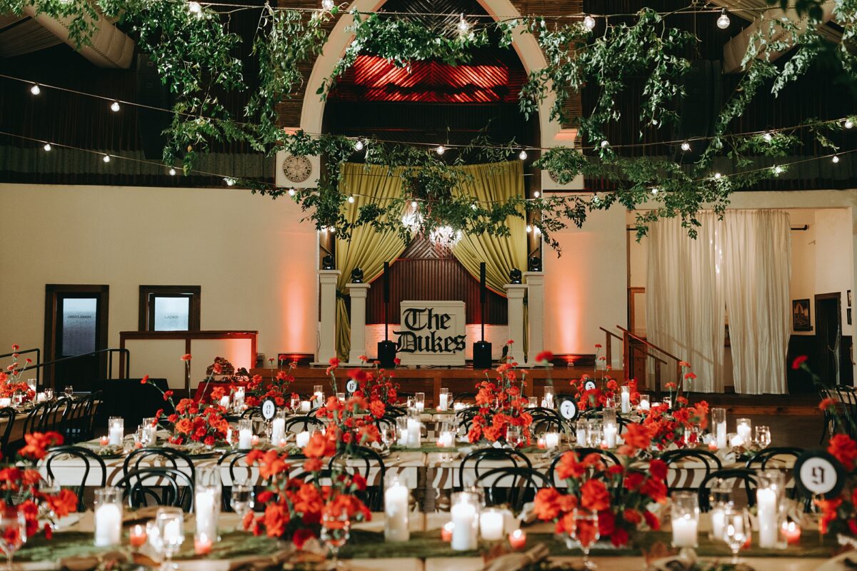Dramatic gothic designed wedding with red roses, candles, and smilax greenery decor at The Brooklyn Arts Center wedding venue