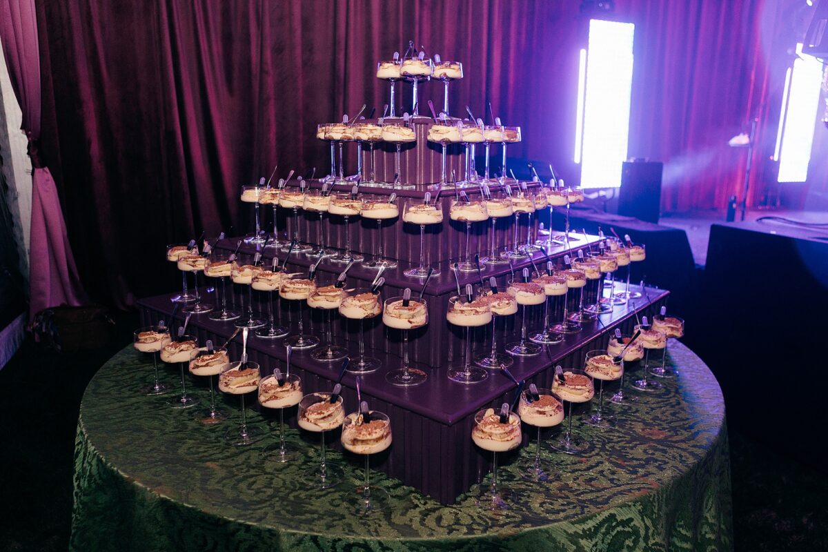 Purple Tiered stand with glasses of dessert displayed for guests at a wedding reception 